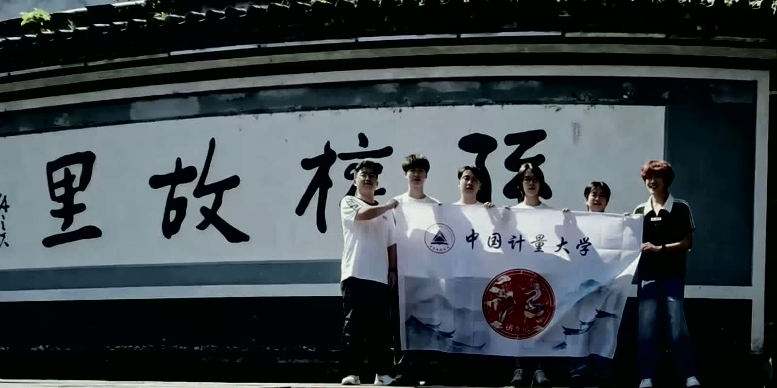团队在孙氏故里题壁前与队旗合影